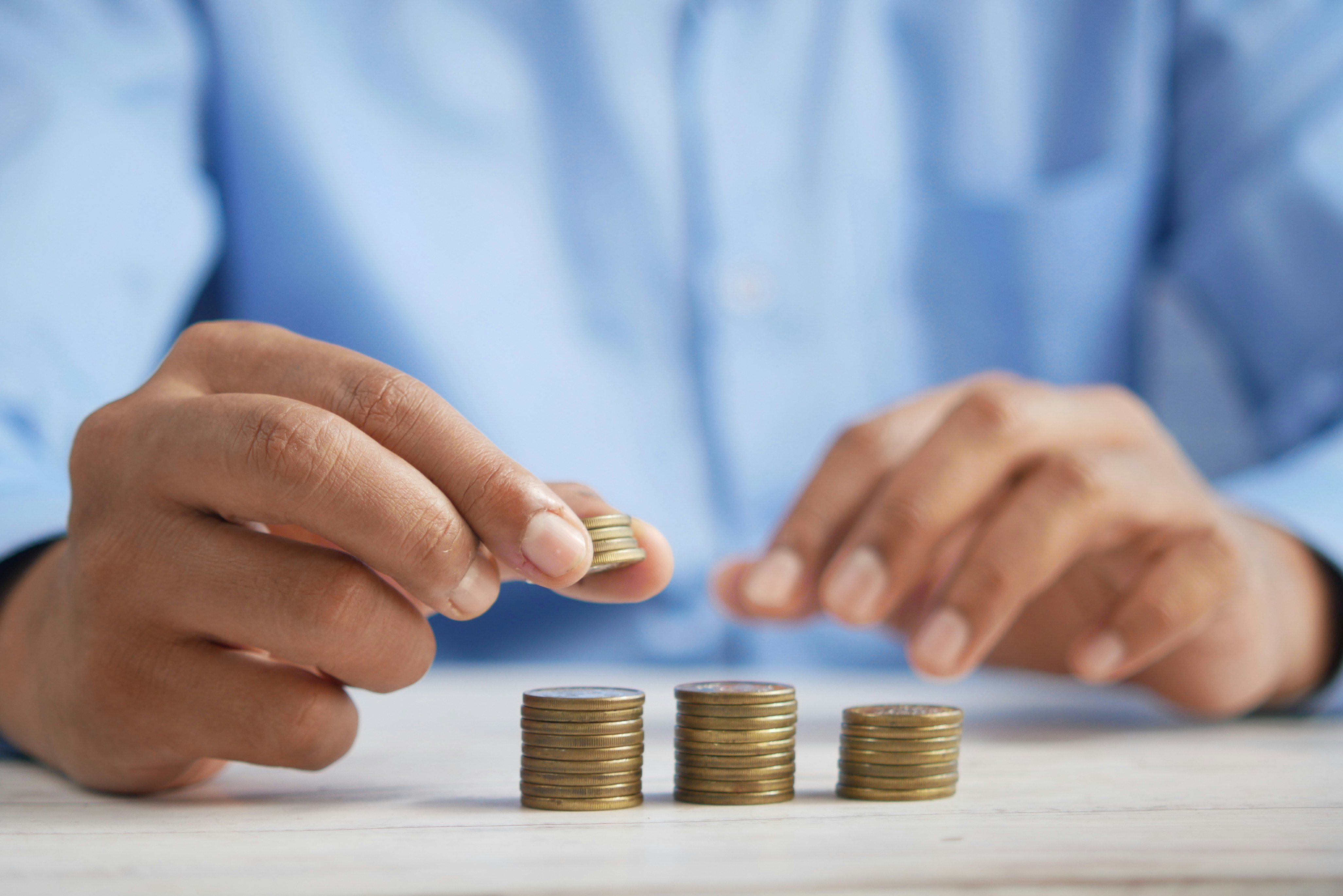 Hands stacking coins on a desk